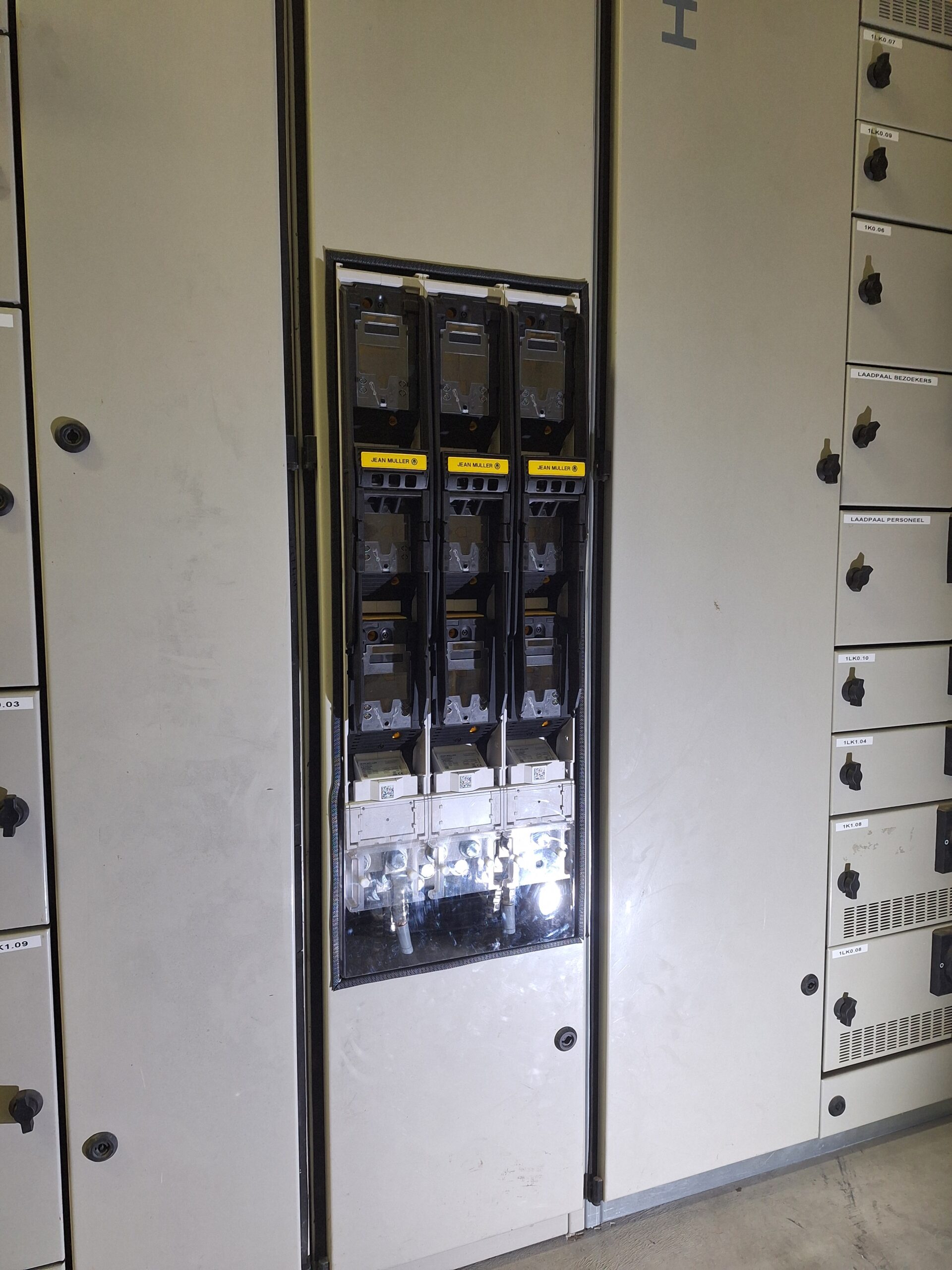 Industrieel elektrisch paneel met zes stroomonderbrekerschakelaars in het middelste compartiment.