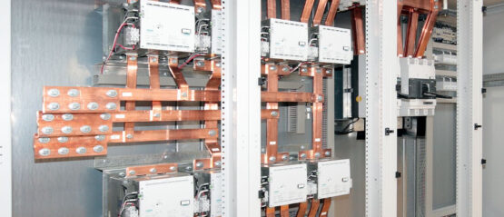 NED-web-cabinet-015 Elektrische schakelkast met grote koperen stroomrails, stroomonderbrekers en elektrische componenten gemonteerd in metalen behuizingen.
